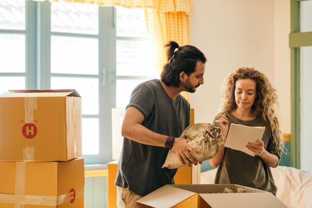 a couple moving into an apartment and looking over a checklist